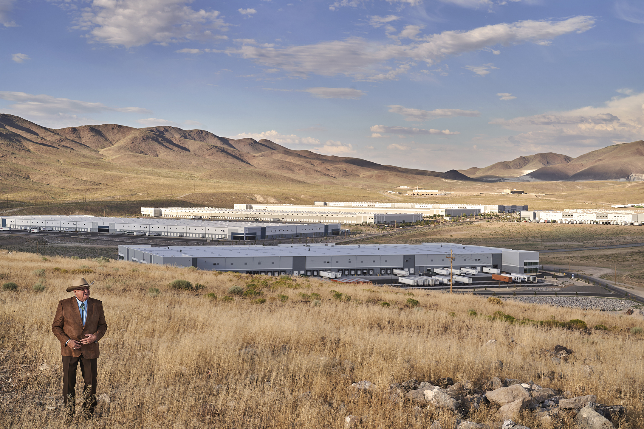 Lance Gilman standing on a hill overlooking building in the industrial center