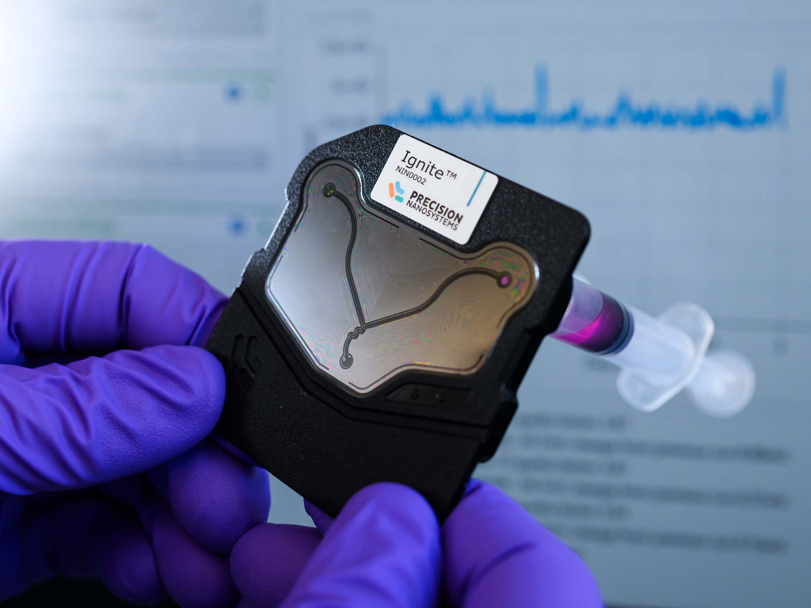 gloved hands hold the device